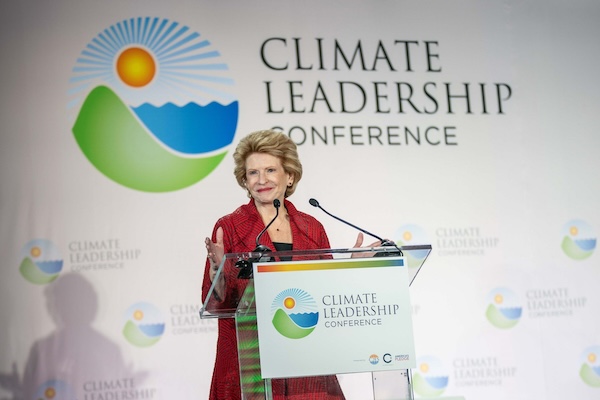 Debbie Stabenow speaking at a podium in front of a sign that says Climate Leadership Conference